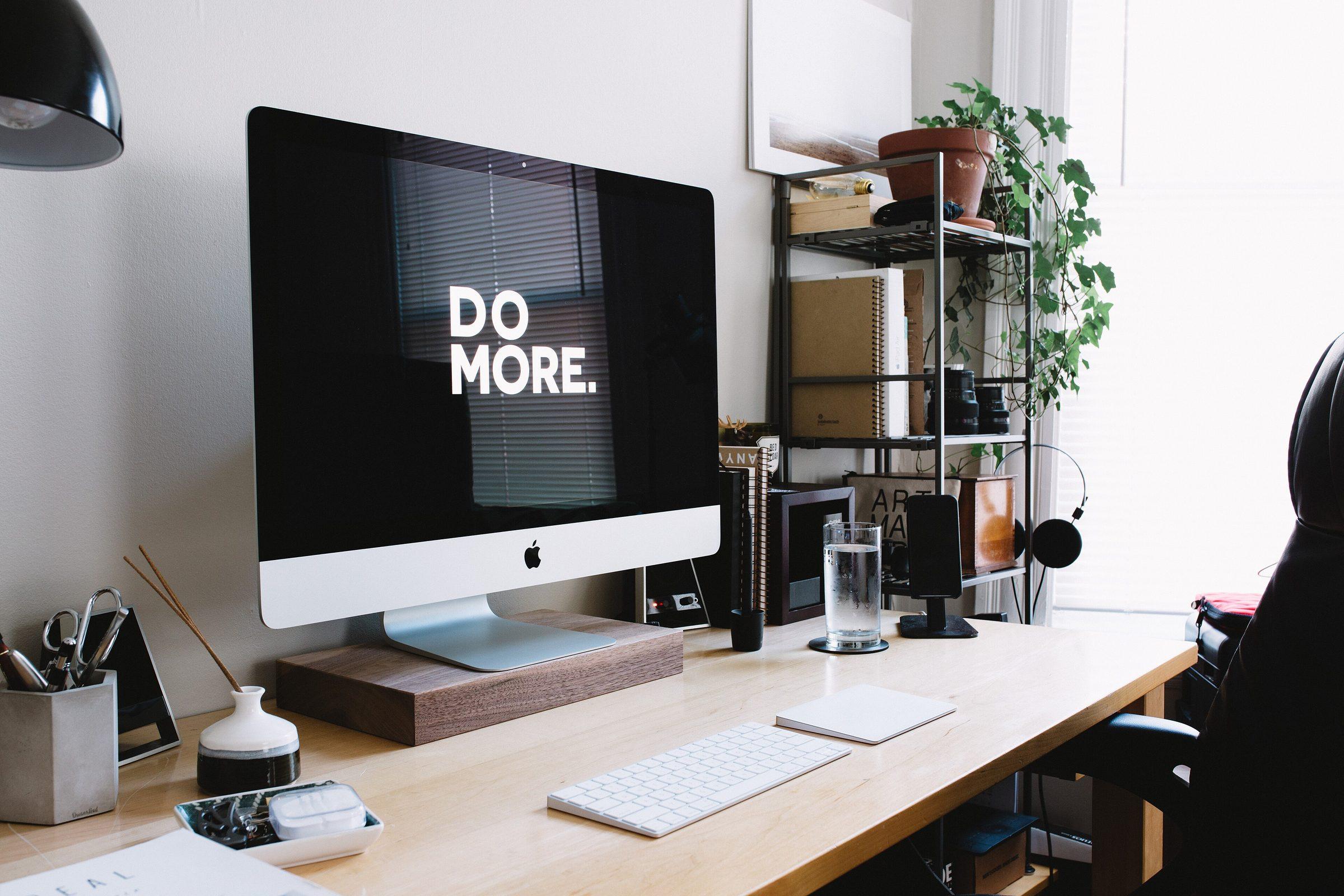 A clean desk with a monitor that reads Do More