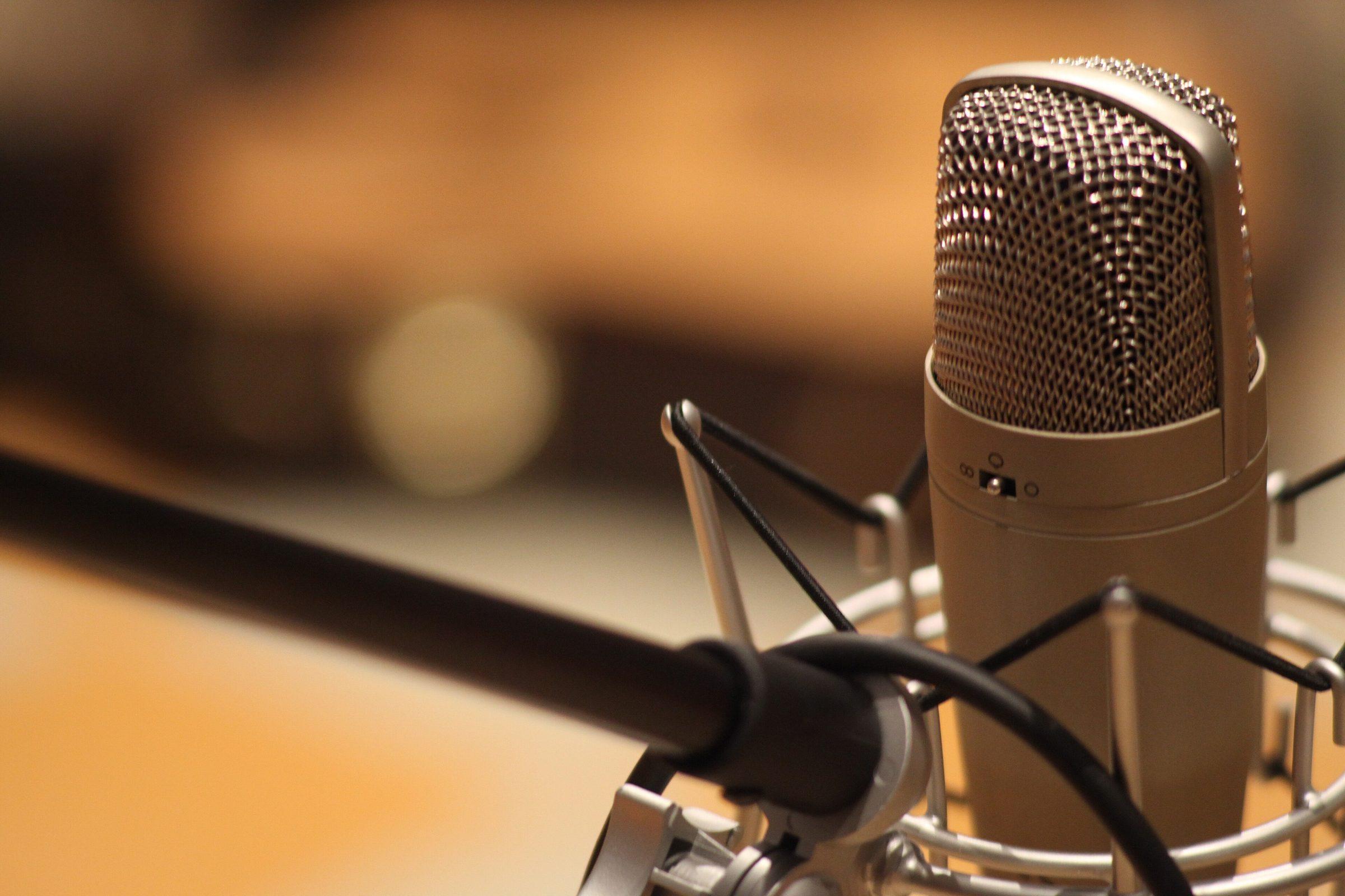 A gold condenser microphone in a studio
